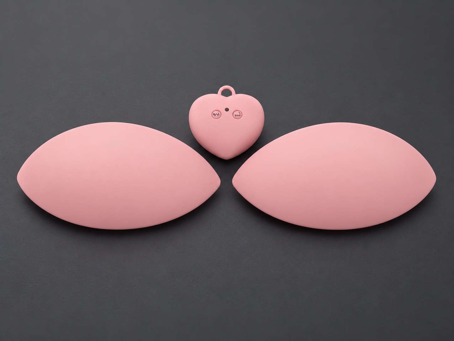 Pink silicone leaf-shaped pads and matching controller, retouched from the original product photograph